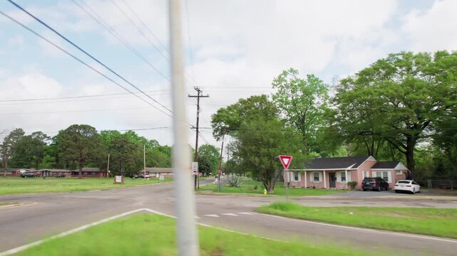 Moving past middle lower class poor neighborhood street homes outside downtown capital city Montgomery, Alabama in historic suburb community with houses, buildings, sidewalk, cars, driveways, and road