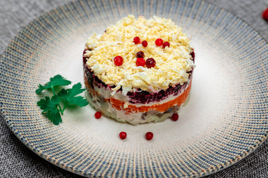 Traditional Russian layered "dressed herring" salad ("Selyodka Pod Shuboy"), close-up shot.