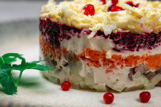 Traditional Russian layered "dressed herring" salad ("Selyodka Pod Shuboy"), close-up shot.