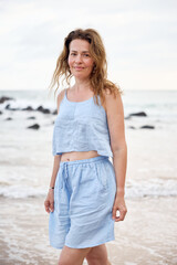 Young girl in blue clothes on the beach