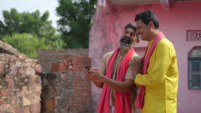 happy indian farmer with friend looking smartphone 
