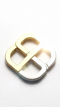 Macro Close Up of Interlocking Gold and Silver Metal Luxury Buckle Rotating Slowly