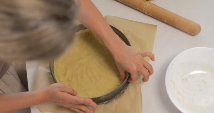 Woman forming shortbread dough in springform pan