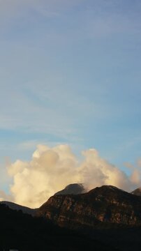 Vertical Time Lapse of Clouds Drifting above Mountains and birds flying away