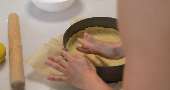 Woman forming shortbread dough in springform pan