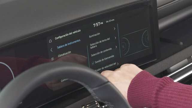 manos de una mujer moviendo los controles de un auto nuevo para configurarlo