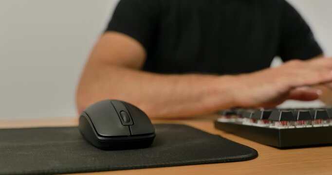 Close-up of man using wireless mouse and mechanical keyboard on desk