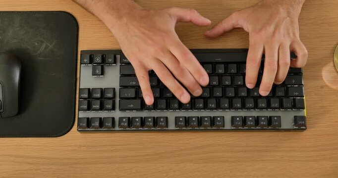 Close-up of man using wireless mouse and mechanical keyboard on desk