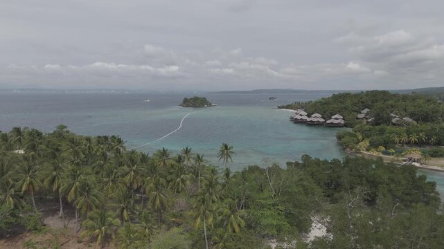 Aerial view of beautiful tropical beach with turquoise water and lush green islands in Samal Islands