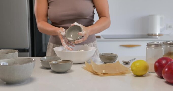 Woman preparing shortbread dough in a modern kitchen.