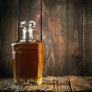 A bottle of liquor sits on a wooden table