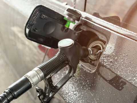 Refueling a black car with diesel fuel at a gas station. Car refueling on petrol station. Fuel pump at station. Refueling a car at a gas station. Fuel nozzle to refill fuel in car at gas. Tank neck. 