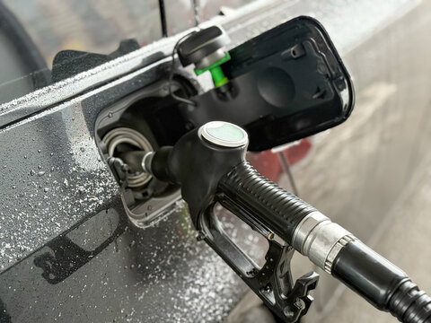 Refueling a black car with diesel fuel at a gas station. Car refueling on petrol station. Fuel pump at station. Refueling a car at a gas station. Fuel nozzle to refill fuel in car at gas. Tank neck. 