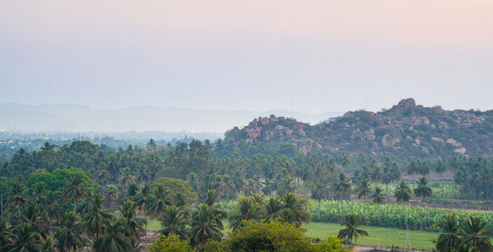 Hampi landscape with rocky boulder terrain, coconut trees and banana plantation, subcontinent India