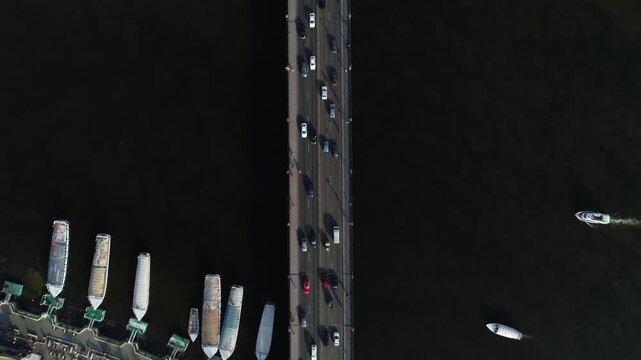 Aerial Top-down View of Cairo Traffic on Nile Bridge with Traditional Boats and City Waterfront, Egypt