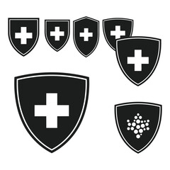 Fototapeta premium Collection of black shield icons with white crosses and a cluster design on a plain background viewed directly