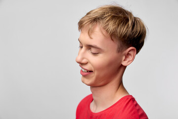 Boy in a red shirt smiles softly, capturing a candid moment of happiness and youthful charm for family, education, and lifestyle themes in stock imagery, ideal for positive messaging and everyday