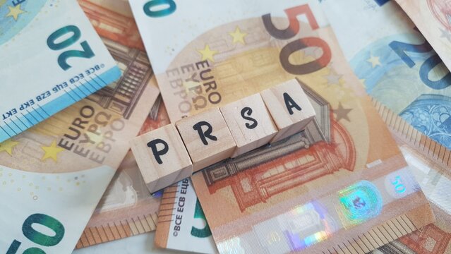 PRSA acronym made of wooden letter cubes on pile of Euro banknotes. Personal Retirement Savings Account