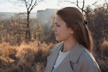 Profile portrait young adult woman enjoying fresh autumn sunny day outdoors © Natalia Navodnaia