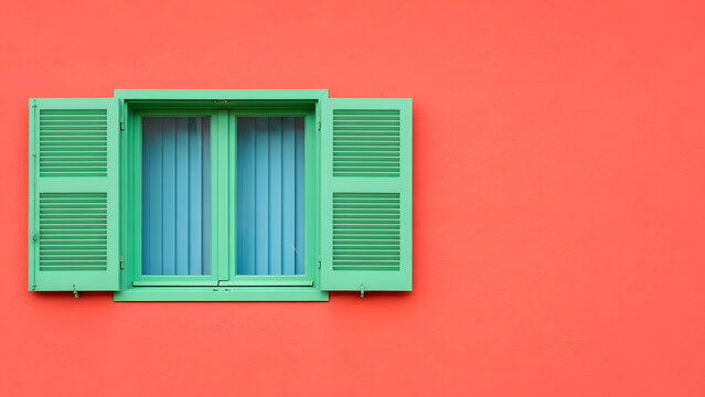 Bright coral stucco wall texture background with copy space | Mint green window frame and open shutters against vibrant orange plaster | Minimalist architectural detail showing high color contrast des