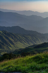 Fototapeta premium Golden Hour Mountain Landscape with Layered Peaks and Verdant Valley