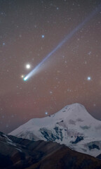 Obraz premium Comet Streaking Over Snow-Capped Mountain Peak at Night