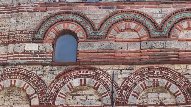Nessebar, Bulgaria - August 25, 2025: Church of Christ Pantocrator. Fragment of the facade of a medieval Orthodox church. Late Byzantine style. Facade with colorful decor, ceramic elements