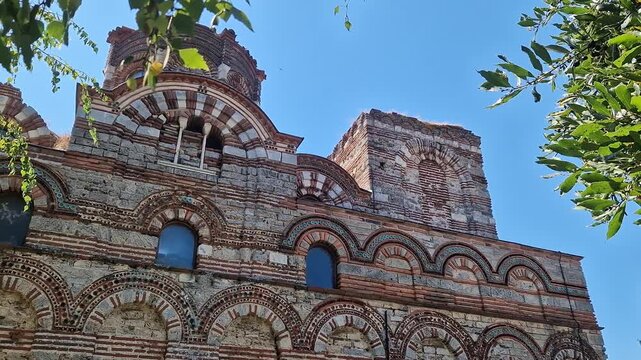Nessebar, Bulgaria - August 25, 2025: Church of Christ Pantocrator. Fragment of the facade of a medieval Orthodox church. Late Byzantine style. Facade with colorful decor, ceramic elements