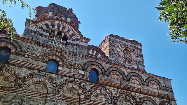Nessebar, Bulgaria - August 25, 2025: Church of Christ Pantocrator. Fragment of the facade of a medieval Orthodox church. Late Byzantine style. Facade with colorful decor, ceramic elements