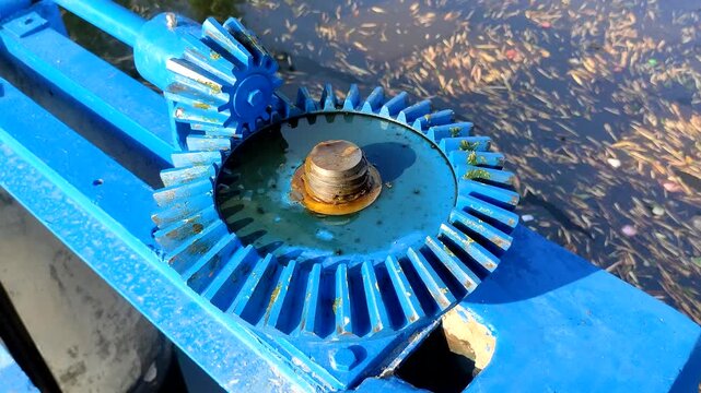 Close up of blue manual bevel gear mechanism on irrigation water gate