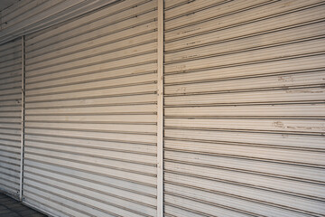 Fototapeta premium Shops in a Bulgarian neighborhood close for the evening and season. Rolling shutters are pulled down, marking the end of the day for local businesses. The street is quiet as day turns to night