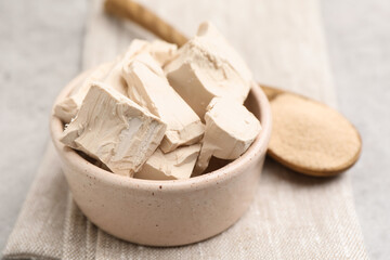 Fresh and dry yeast on light grey table, closeup