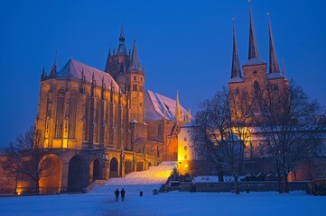 Obraz premium cathedral square in Erfurt with view to snow covered cathedral and church Severi at a winter day in the blue hour