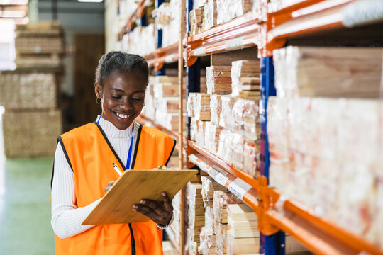 Warehouse worker checking inventory list in lumberyard