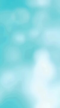 Light blue abstract background with white blurred spots. Light movement creates soft lens flare bokeh effect. Vertical video