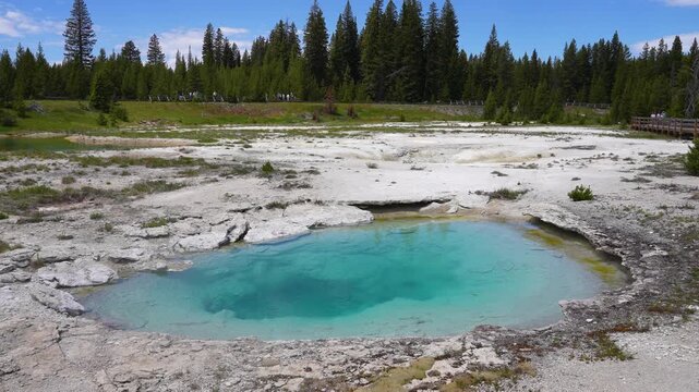 Close-up shot of vivid blue water formed by geothermal activity near Yellowstone Lake in Yellowstone National Park, Wyoming. Detailed natural scene highlighting steaming hot spring water and unique ge