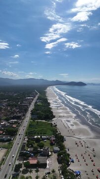 Vista a&eacute;rea da Praia de Boraceia evidenciando a longa extens&atilde;o de areia, o mar do litoral norte e o cen&aacute;rio urbano de Bertioga.
