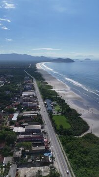 Vis&atilde;o a&eacute;rea vertical da orla da Praia de Boraceia destacando a extensa praia, o mar calmo e a urbaniza&ccedil;&atilde;o linear t&iacute;pica do litoral paulista.