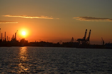 Obraz premium Port silhouette with cranes at dramatic sunset