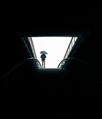 man with umbrella in a dark tunnel