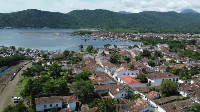 Aerial shot of Paratys UNESCO historic center with view over the bay and the majestic mountains. Captures colonial architecture, the Atlantic forest, and the bay from above.