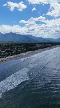 Imagem a&eacute;rea panor&acirc;mica da Praia de Boraceia mostrando o mar aberto, a areia clara e o desenvolvimento urbano ao longo da orla em Bertioga