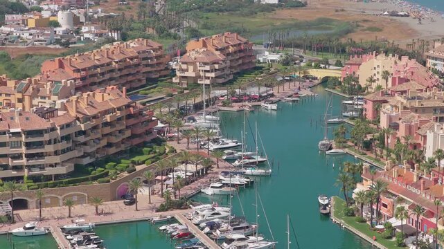Aerial view showing sotogrande marina, a luxury residential and leisure resort with yachts, boats, and colorful waterfront apartments