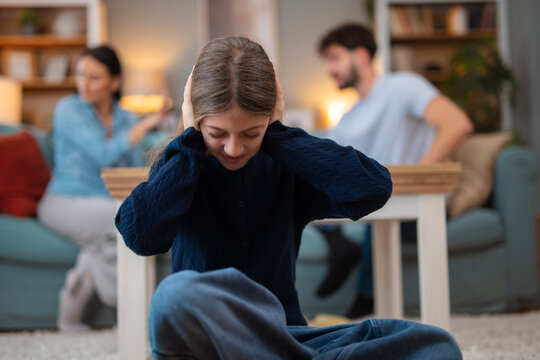Child covering ears during parents fighting at home