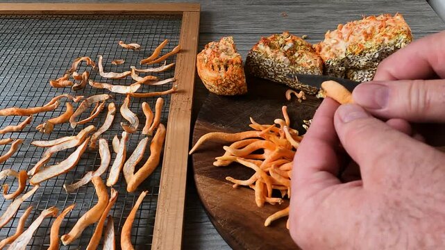 Processing medicinal mushrooms Cordyceps militaris or Scarlet Caterpillarclub and preparing them for drying, cutting them in half for easier and faster drying
