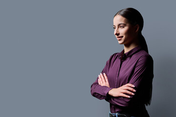 Profile portrait of young confident woman on gray background © Valerii Honcharuk