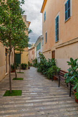 Obraz premium Historic town of Alcudia in Mallorca, known for its well-preserved medieval walls, charming old streets, and lively atmosphere. A popular destination offering cultural heritage, local shops, and tradi