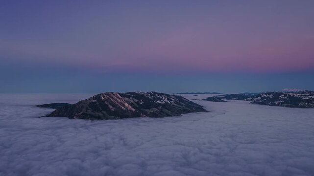 Aerial view of mountain isand in sea of clouds at puple twilight