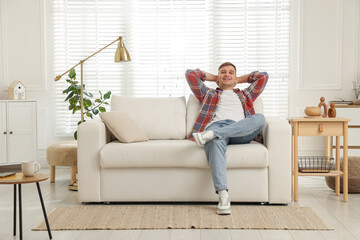 Fototapeta premium Young man relaxing on sofa at home