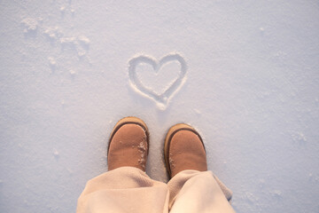 Heart Drawn in Snow Near Winter Boots. Romantic Love Concept, Cozy Cold Season Background, Valentine Mood Outdoor Minimal Composition